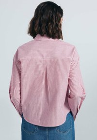 Rood en wit gestreept shirt met een rugpand, met knoopmansjetten en een ronde zoom. Gemaakt van lichte stof, met een relaxte pasvorm.