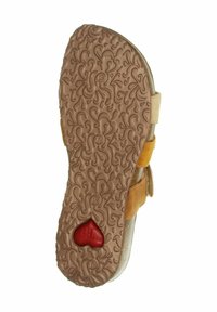 Sole in gomma marrone con motivo intricato, dettagli in suede giallo e un cuore rosso. Fissato da una fascia regolabile per una vestibilità sicura.