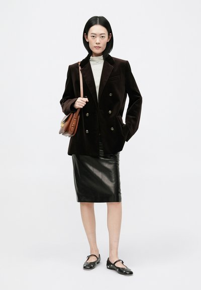 Brun fløjl dobbeltbrystet blazer, tætsiddende gråstribet top, sort læder blyantnederdel og sort fodtøj med dekorative detaljer.