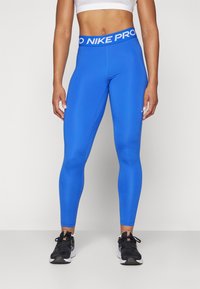 Plave Nike Pro tajice s širokim pojasom na kojem se nalazi bijeli branding, izrađene od glatkog, rastezljivog materijala, namijenjene za sportsku odjeću.
