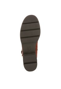 Bruine suede laarszool met horizontale groeven, ronde vorm en platte hak. Bevat een reliëfbranding op het hielgedeelte.