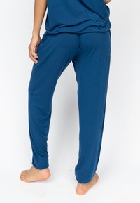 Blauwe, loszittende pyjamabroek van zachte stof, met een elastische waistband, zijzakken en taps toelopende enkels.