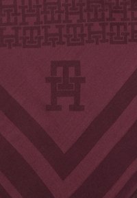 Burgundy fabric features a textured pattern with interlocking 'H' shapes and chevron stripes, creating a layered visual effect.