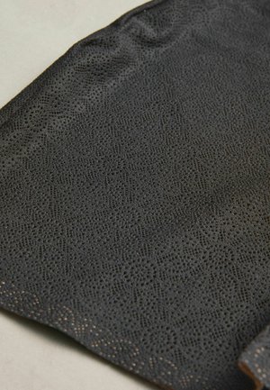 Black, textured fabric featuring a lace-like pattern with intricate designs. The edge is smooth, enhancing its delicate appearance.