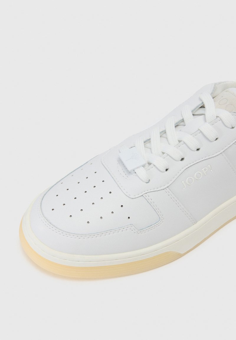 Weiße Leder-Sneaker mit perforierter Zehenkappe für Atmungsaktivität, flachen weißen Schnürsenkeln, geprägtem "JOOP!"-Logo und einer leichten Gummisohle.