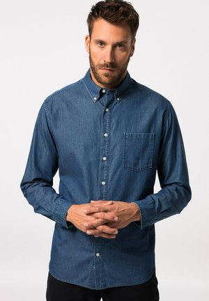 Camisa de mezclilla azul oscuro con botones, bolsillo en el pecho, mangas largas y cuello clásico. Textura suave y ajuste entallado.