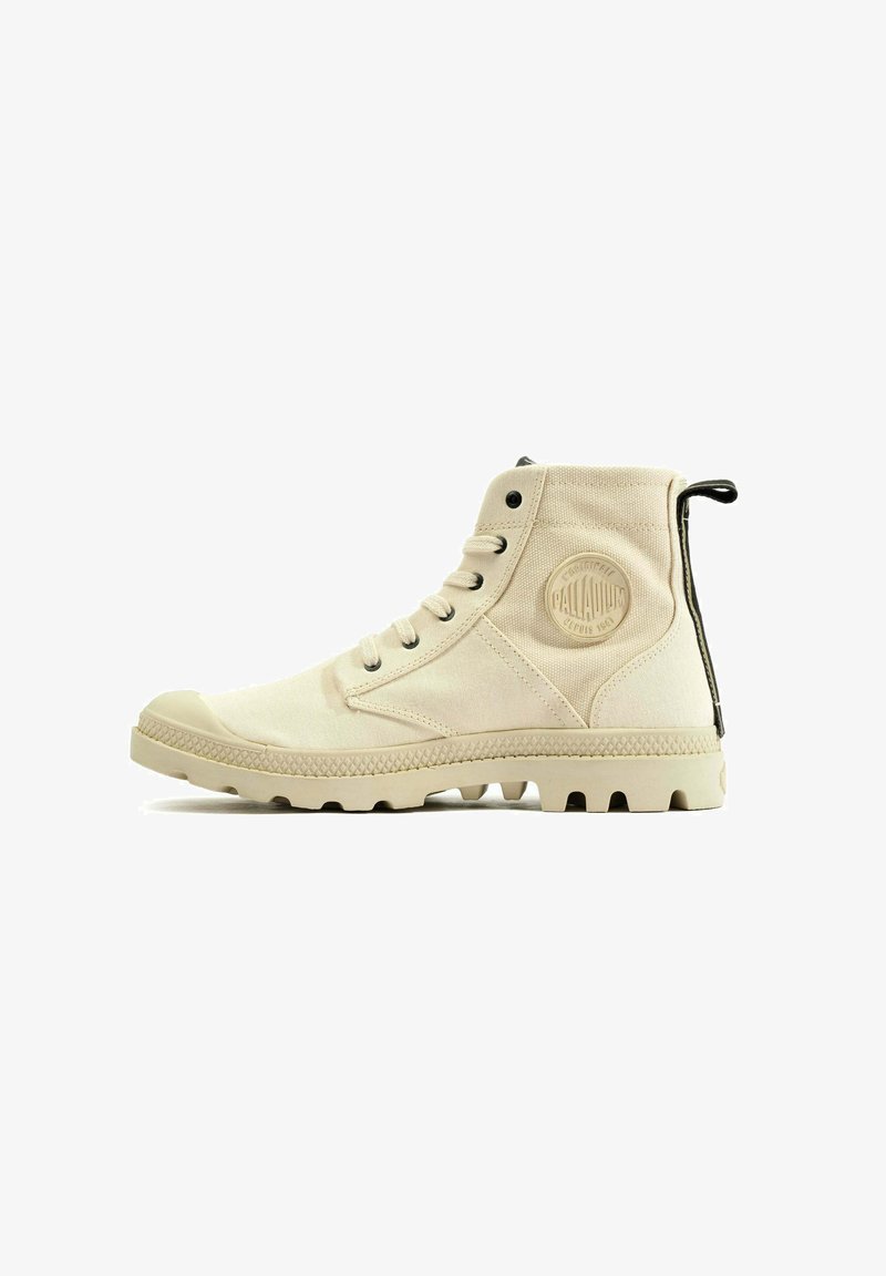 Beżowy wysoki but wykonany z płótna, z gumową podeszwą i teksturowanymi akcentami. Posiada okrągłą łatę z logo oraz pętelkę na pięcie.