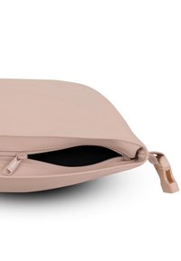 Borsa a tracolla rosa chiaro con una superficie liscia, chiusura con zip e fodera interna nera. La ferramenta della zip è discreta e funzionale.