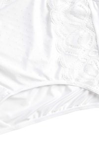 Witte lingerie met een gladde satijnen textuur en delicate kantafwerking. Bevat een klein stippenpatroon op de stof, wat de visuele details versterkt.