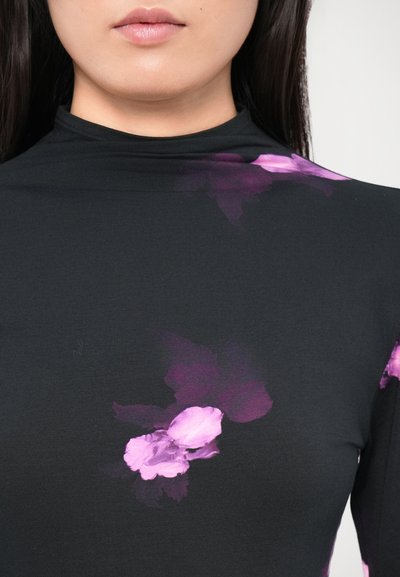 Black top featuring a high neck and long sleeves, adorned with purple floral patterns on one side, made from a smooth fabric.