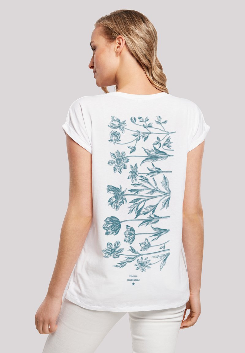 White t-shirt with rolled short sleeves, featuring a blue floral design on the back, displaying various flowers and leaves in an arranged pattern.