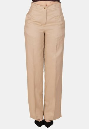 Pantaloni beige a vita alta e gamba dritta con bottone e zip frontale, indossati con scarpe nere a punta.