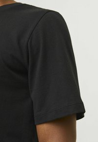 Sort bomulds t-shirt med korte ærmer, blød tekstur og en ren syning, uden synlige logoer eller mønstre.