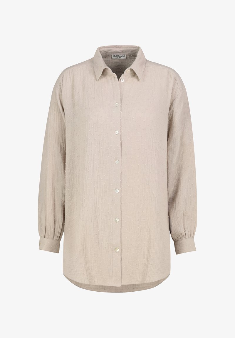 Hellbeiges Hemd zum Knöpfen mit strukturiertem Muster, langen Ärmeln mit gerafften Bündchen und einem abgerundeten Saum, versehen mit kleinen, runden Knöpfen.