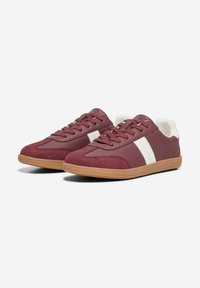 Maroon sporty sneakers with a smooth upper, white stripes, and textured gum rubber sole. Features lace-up design and padded collar.