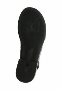 Suola di scarpa in gomma nera con scanalature testurizzate, dotata di marchio impressa. Forma piatta e arrotondata con un leggero tacco per il comfort.