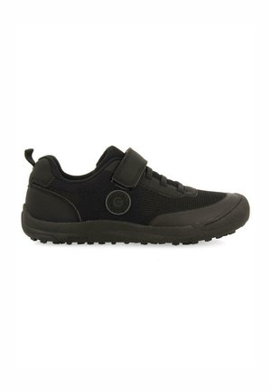 Zapatilla deportiva negra con parte superior de malla, suela de goma y tira de Velcro ajustable. Diseño simple con textura suave y forma redondeada.