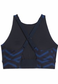 Sujeción deportiva en color navy con parte superior texturizada y un patrón de chevron en la parte inferior. Cuenta con tirantes ajustables en forma de cruz y un cierre de gancho.