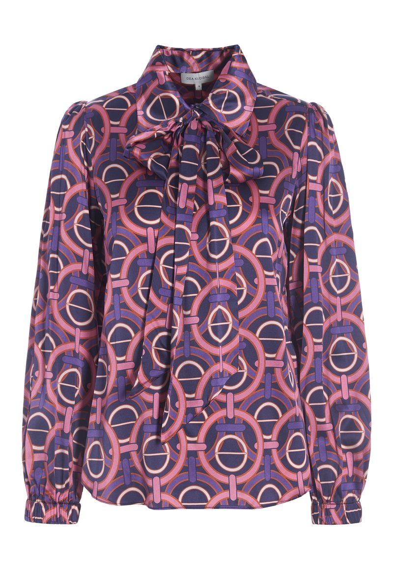 Blouse violette à manches longues avec motif géométrique circulaire rose et orange, col montant et détail de nœud noué à l'avant.