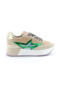 Beige suède platform sneaker met glanzend groene sterontwerp en zilveren accenten, voorzien van zwart-wit gestreepte veters en een gestructureerde hak.