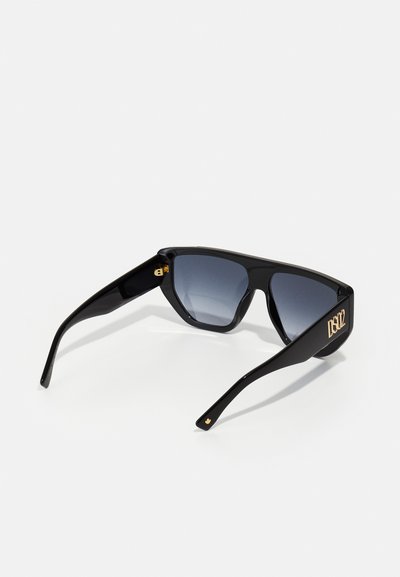 Occhiali da sole neri con una montatura spessa e lenti grigie sfumate. Presentano dettagli in oro con logo sulle astine. Texture liscia in tutto il prodotto.