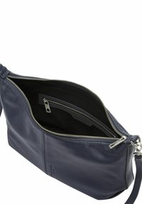 Navy niebieska skórzana torba z srebrnym zamkiem, otwarta, aby pokazać czarne materiałowe wnętrze oraz wewnętrzną kieszeń na zamek.