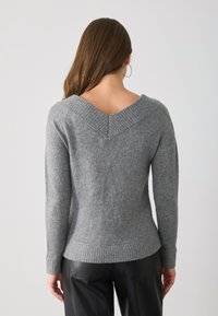 Maglione grigio a maglia con scollatura a V sul retro, orlo e polsini a coste, design aderente e texture morbida. Nessun motivo o decorazione visibile.