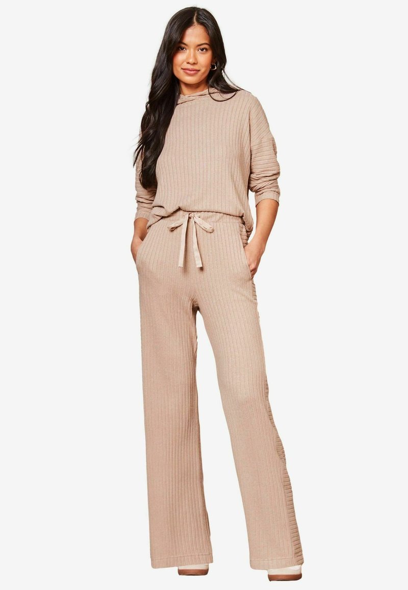 Conjunto de loungewear de color beige con relieve que incluye una camiseta de manga larga con capucha y pantalones de pierna ancha con cintura elástica y bolsillos laterales.
