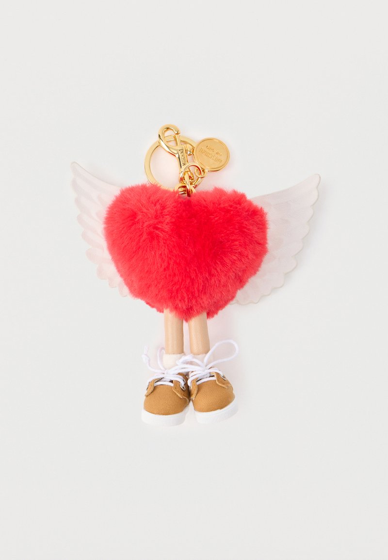 Cœur rouge duveteux avec des ailes blanches, de petites jambes en bois et des baskets marron attachées à un porte-clés doré avec un mousqueton et un charm.