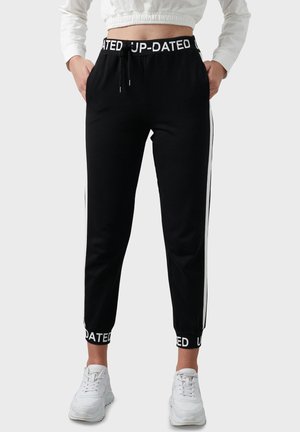 SLIM FIT - Tracksuit bottoms - black