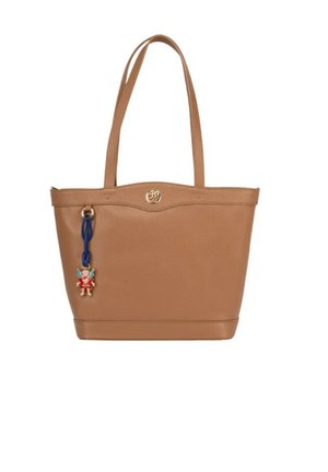 Hellbraune Ledertasche mit zwei Schulterriemen, einem goldenen runden Logo oben in der Mitte und einem blauen Riemen mit einem kleinen Engelanhänger.