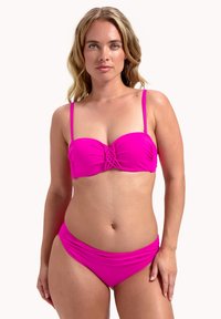 Costume da bagno fucsia brillante composto da un top bandeau con un design attorcigliato al centro. Spalline regolabili e slip a vita media coordinati.