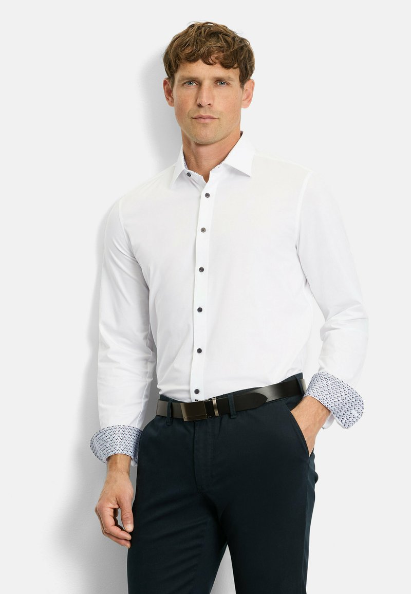 White button-up shirt with contrasting patterned cuffs, black buttons, and a smooth texture, paired with dark trousers and a black belt.