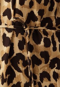 Tela de estampado de leopardo en tonos marrón y beige con una superficie texturada y detalle de cinturón atado. Presenta manchas de leopardo de diferentes tamaños.