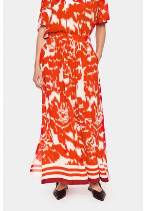 Rotes und weißes Maxikleid mit abstraktem Muster, geraffter Taille, kurzen Ärmeln und gestreitem Saum. Der Stoff wirkt leicht und fließend.