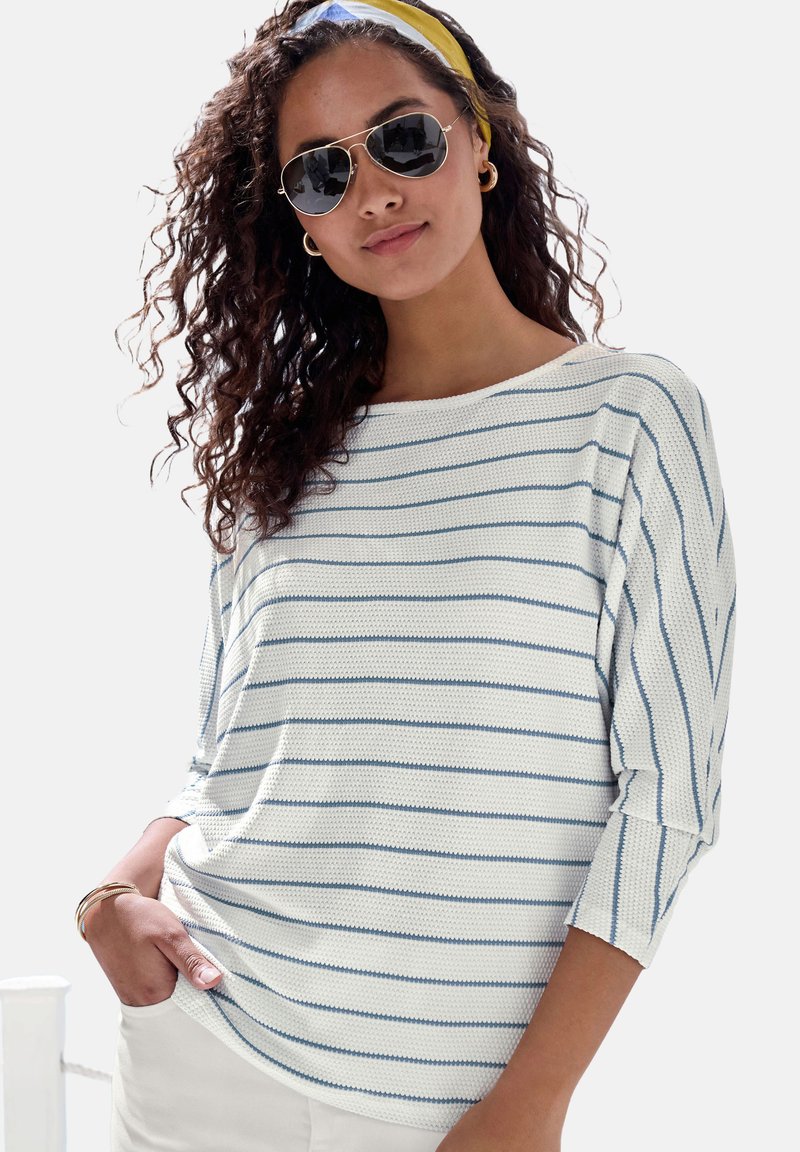 Gestreifte Bluse aus Strickstoff mit blauen horizontalen Streifen auf weißem Hintergrund, weitem Ausschnitt und Dreiviertelärmeln.