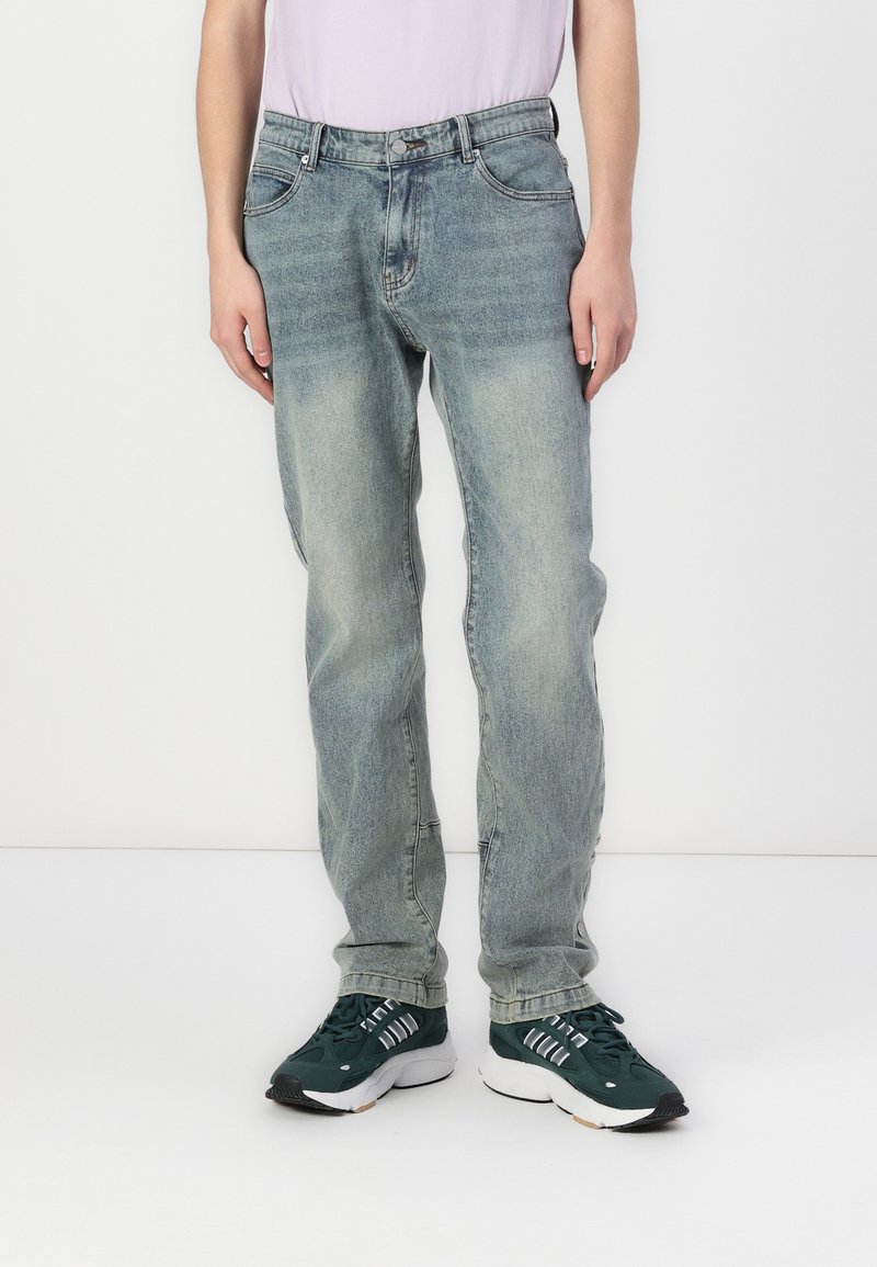 Lyseblå denim jeans med en afslappet pasform, falmet struktur, fem lommer og en frontlukning med knap. Sættes sammen med mørkegrønne sneakers.