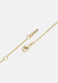 Goudkleurige metalen ketting met een veeraanclip, voorzien van een kleine bar-tag gegraveerd met "PILGRIM." Gladde textuur en slank design.