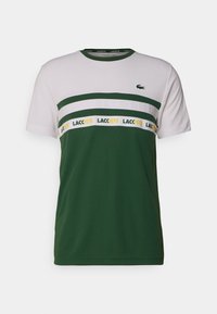 Zelené a bílé pánské tričko z bavlny s horizontálními pruhy, na kterém je značka "LACOSTE" a krokodýlí logo na hrudi.