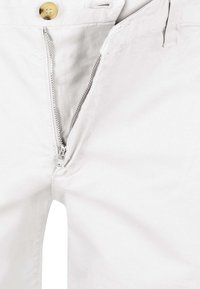 White cotton trousers with a zip fly, featuring a gold button closure and a clean, smooth texture. Detailed stitching along the seams.