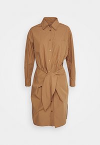 Abito camicia in cotone marrone con colletto, maniche lunghe, bottoni frontali e vita legata. Presenta una tasca sul petto e spacchi laterali.