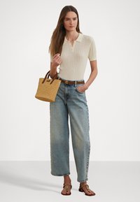 Krems krāsas ribotā polo krekls, augsti vērtas gaiši zils platās kājas džinsi, austi tumši brūni rokassomi ar brūniem rokturiem un gaišas brūnas sandalītes.