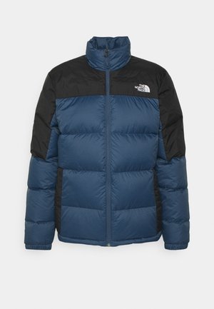 Padded jacket featuring a blue body, black shoulders, high collar, and zip closure. Textured fabric with logo on chest.