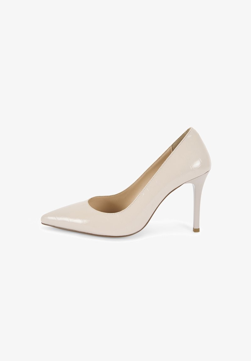 Escarpin en cuir verni beige avec un bout pointu et sans embellissements. Le talon est fin et mesure environ 10 cm de hauteur.