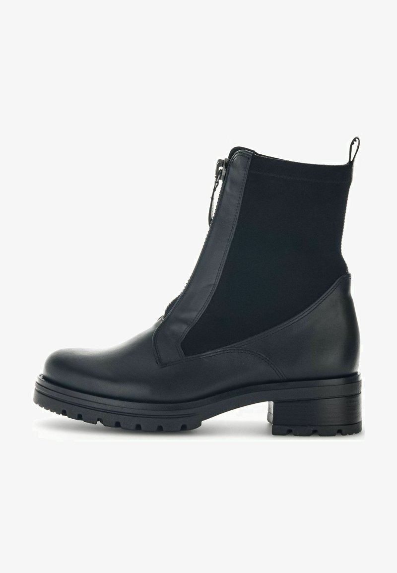 Botines negros con puntera y tacón de cuero suave, paneles laterales elásticos y cierre de cremallera para facilitar su uso. Suela gruesa con relieve.