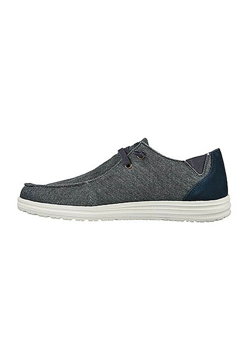 Zapatillas de tela gris con acentos en azul marino, suela blanca, punta redondeada, dos ojales para los cordones y parte superior texturizada para mayor durabilidad.