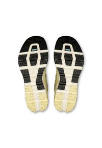 Könnyű futócipő talpok, amelyek fekete és krém színű, többrétegű dizájnnal rendelkeznek, csúszásmentes mintázattal és kyán közelében lévő akcentussal a saroknál.