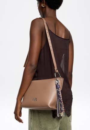 Torba na ramię w kolorze koniakowym z fakturowanym wykończeniem, ozdobiona plecioną frędzlą i srebrnymi elementami. Obecny jest regulowany pasek.