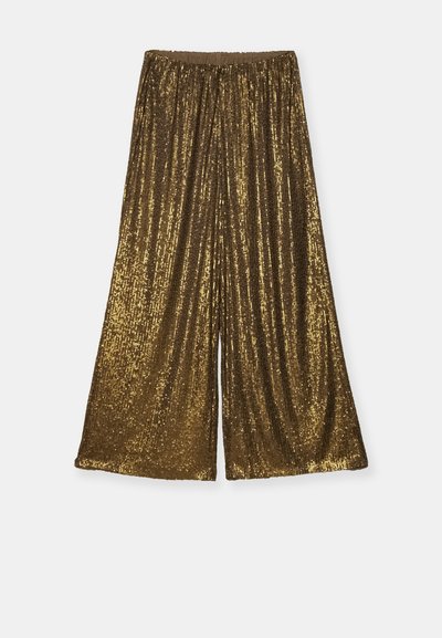 Złote spódnice o szerokich nogawkach z elastycznym pasem. Tekstura jest błyszcząca i odblaskowa, z pionowymi paskami z cekinów.