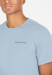 Ljusblå kortärmad t-shirt i mjukt tyg. Har rund halsringning och en liten svart "ENDURANCE"-logotyp framtill.
